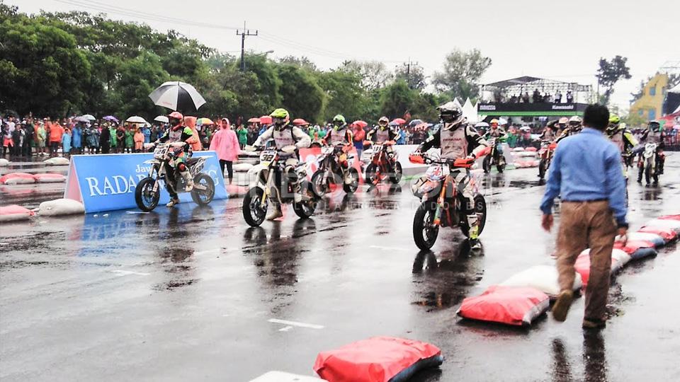 Guyuran hujan tak menyurutkan antusiasime penonton FIM Asia Supermoto. - INDOSPORT